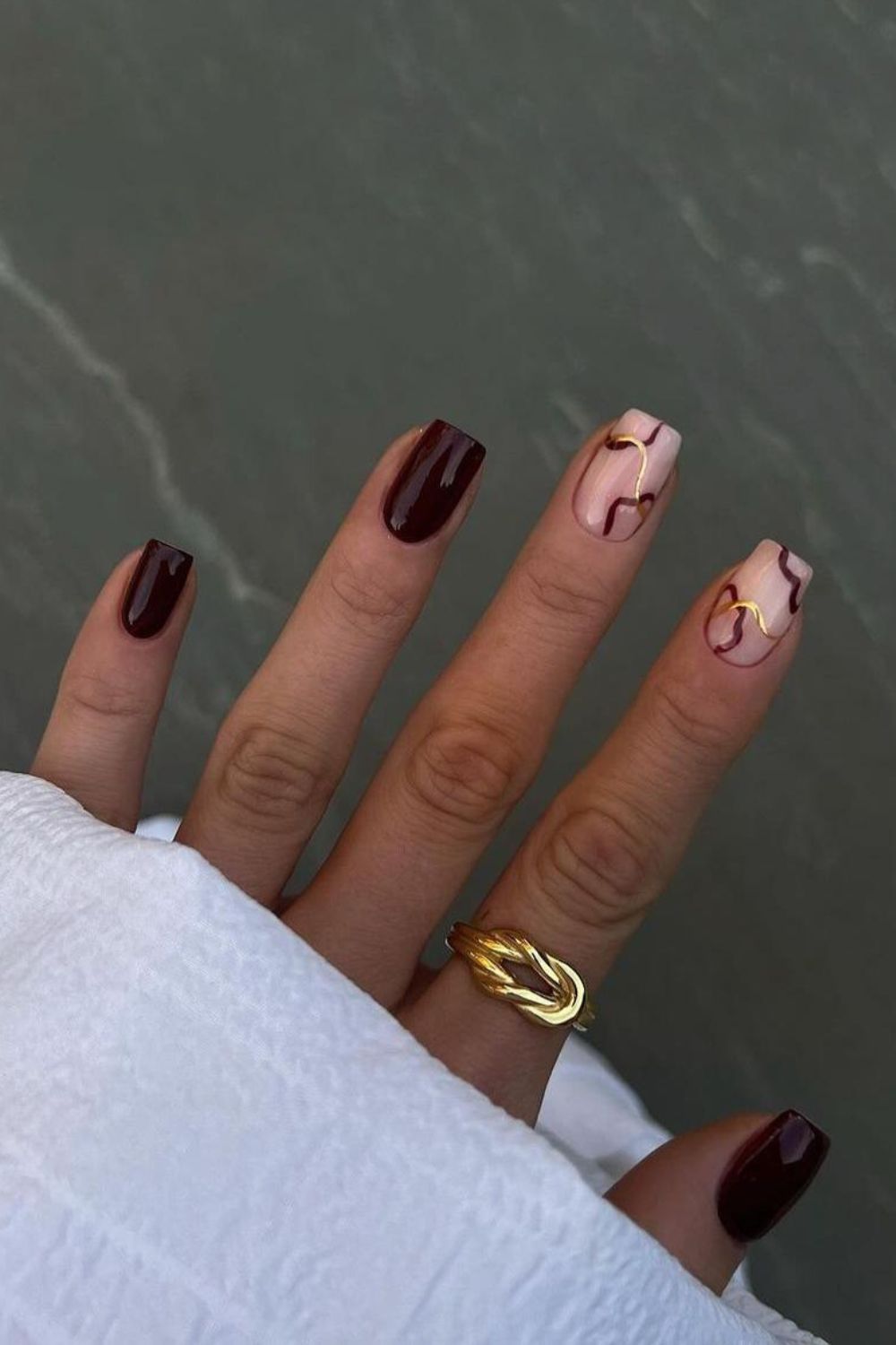 Burgundy manicure with gold chrome lines