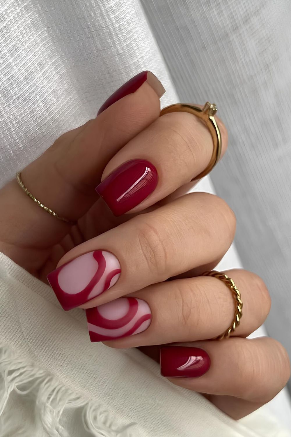 Cherry red nails with abstract swirls