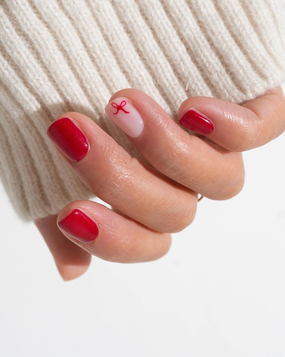 Classic red nails with a simple bow accent