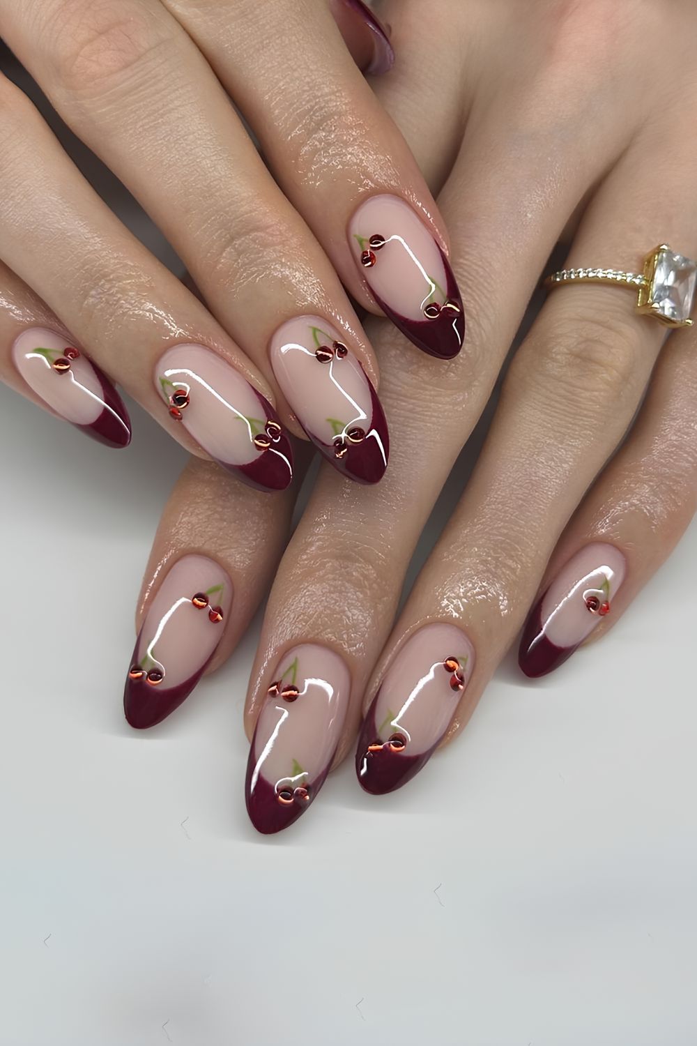 Dark burgundy French nails with cherry accents