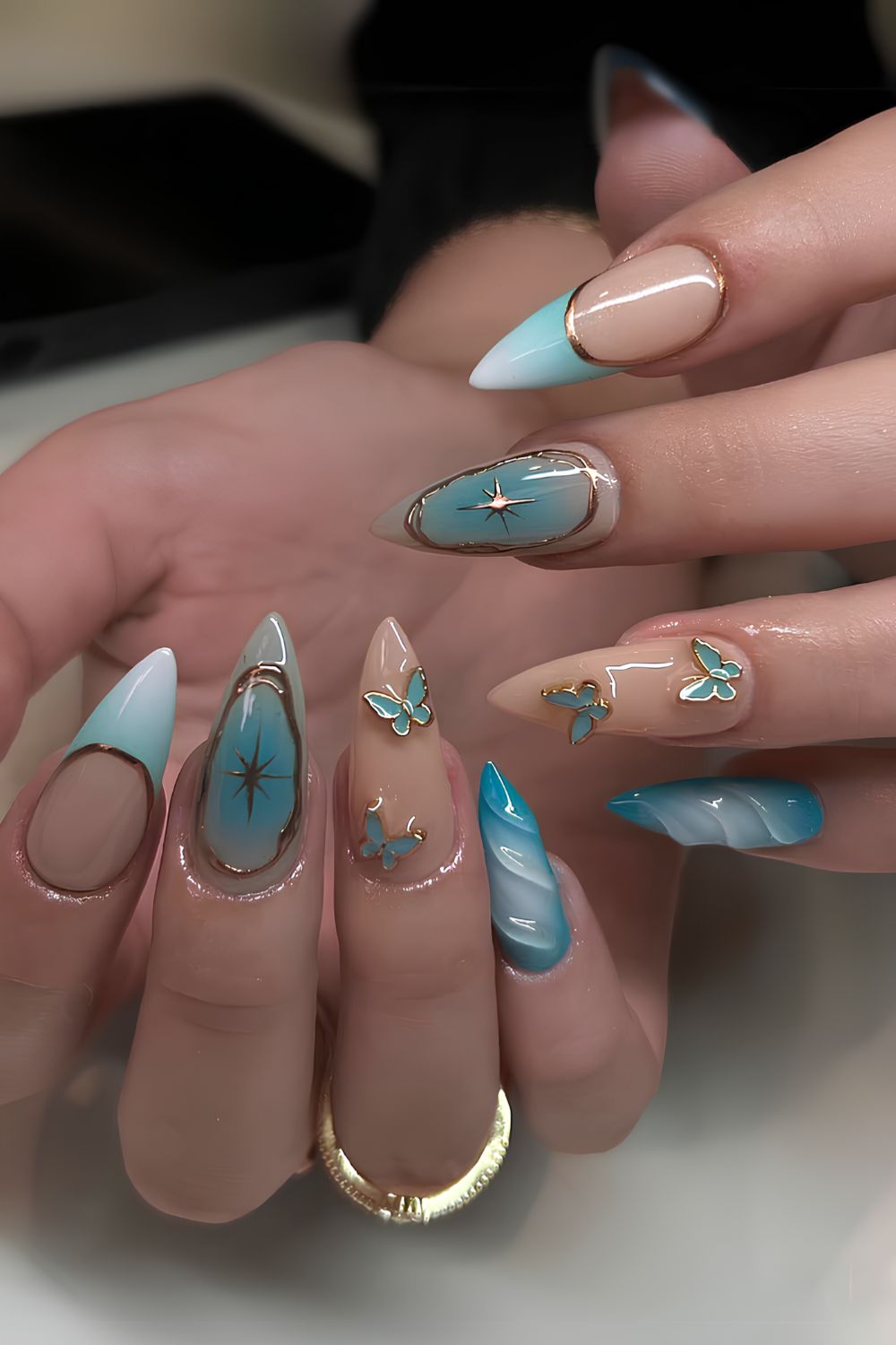 Light blue nails with gold and butterfly accents