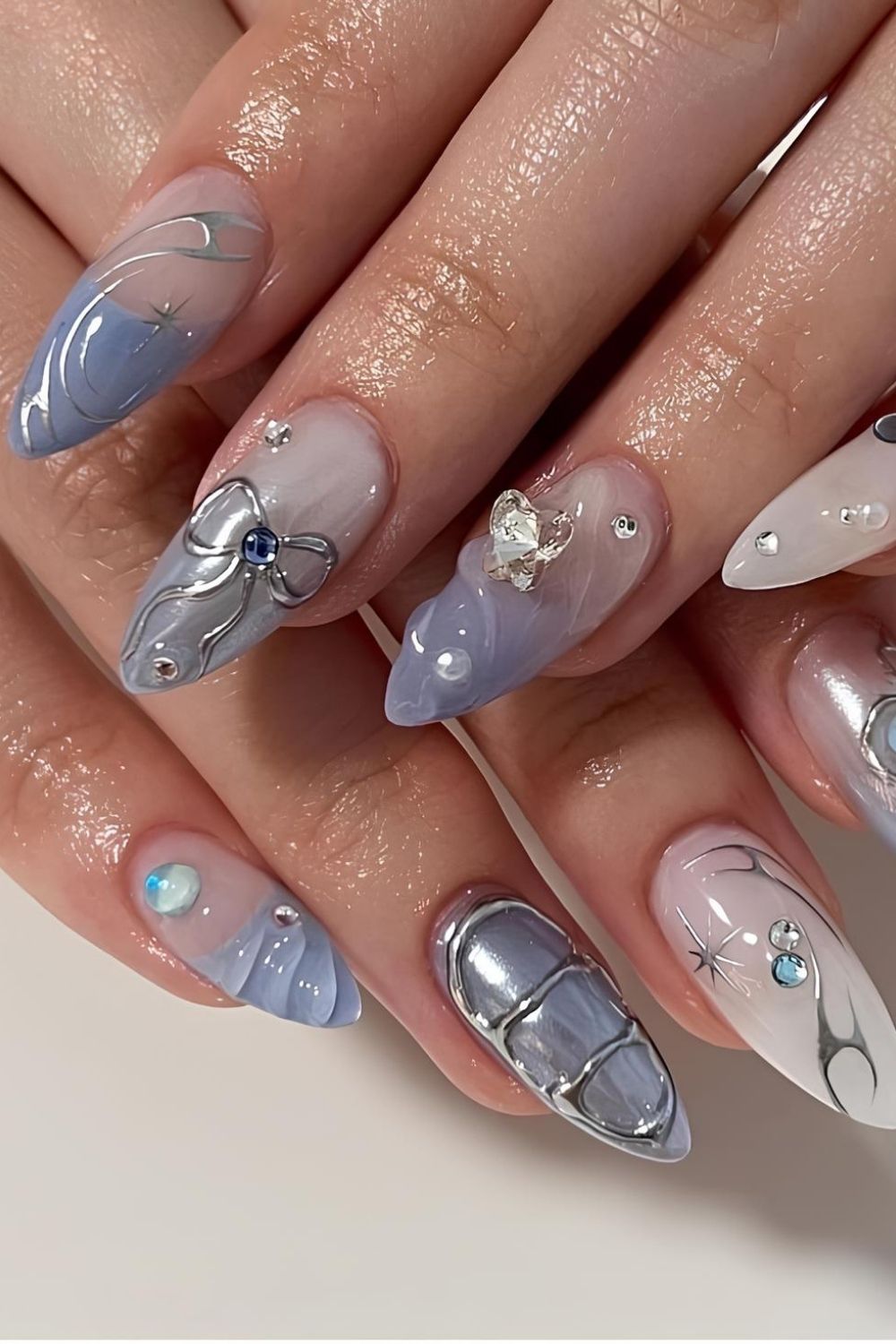 Milky white and soft blue nails with silver chrome accents