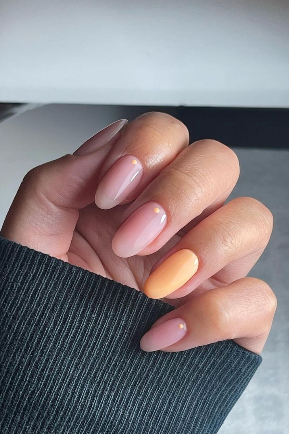 Nude and peach nails with dot accents