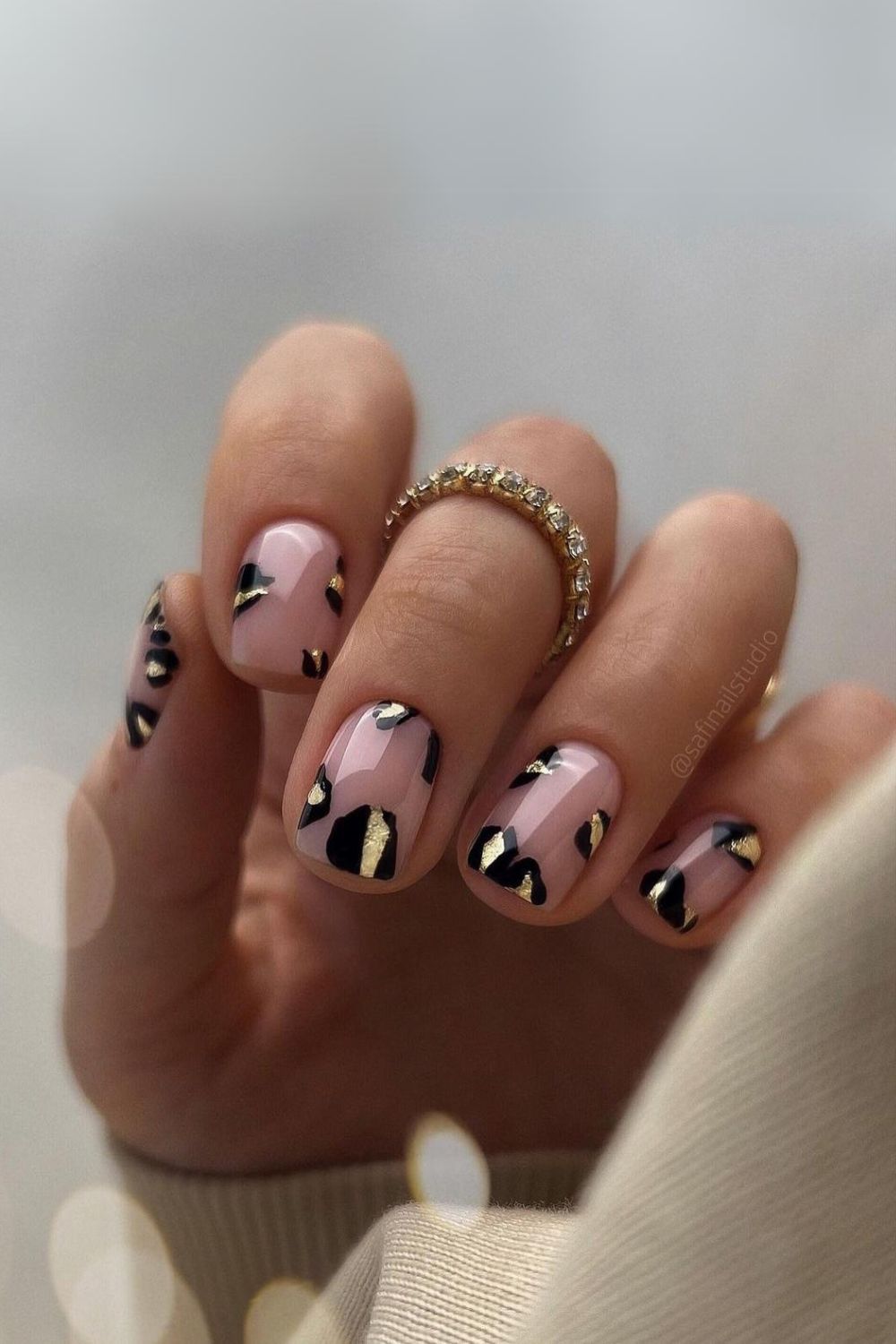 Nude nails with black and gold leopard spots