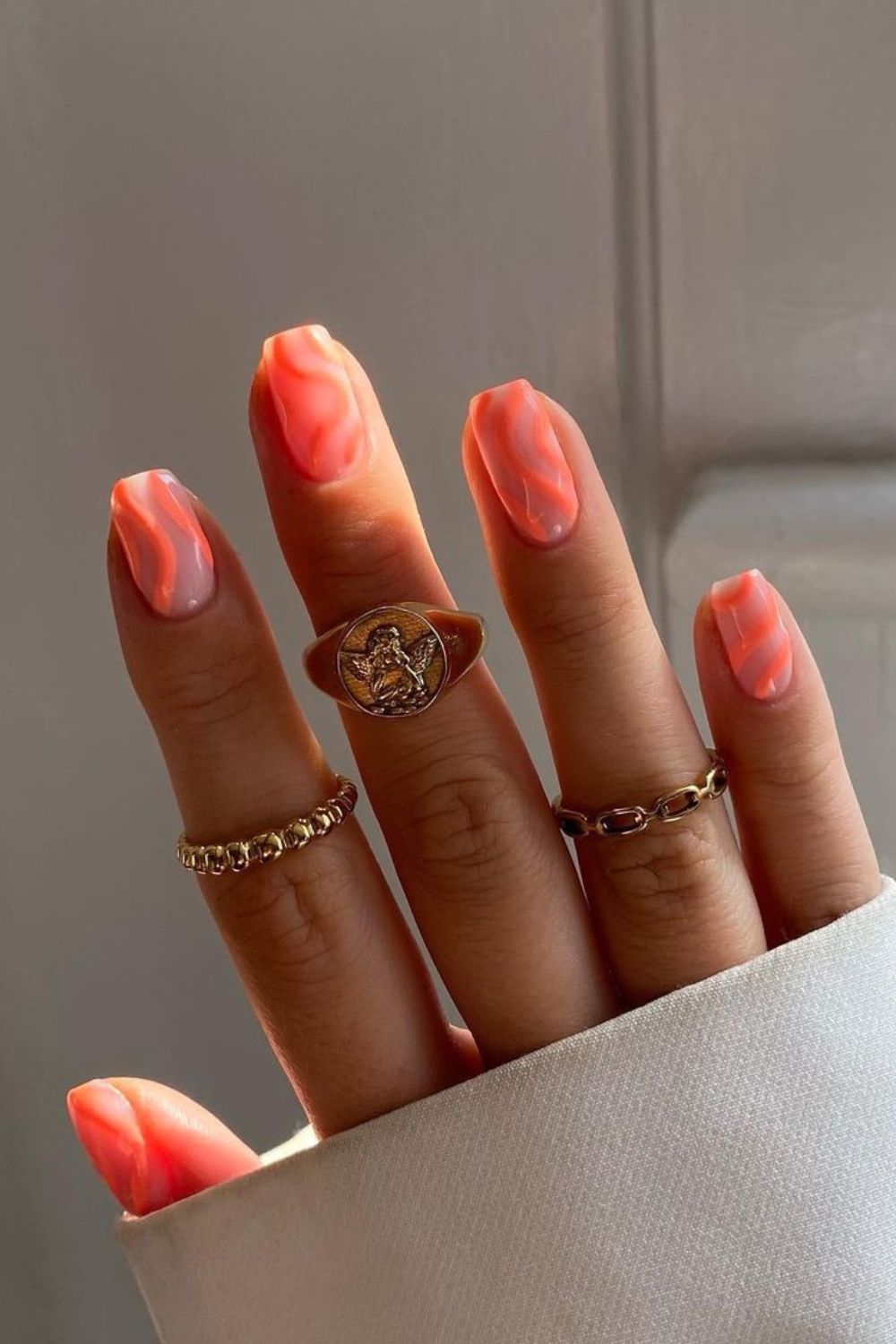 Nude nails with neon peach swirls