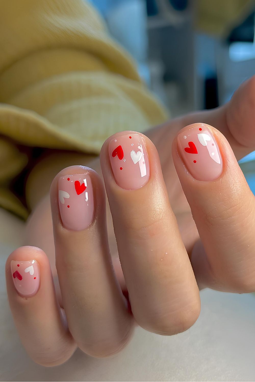 Pink nails with tiny white and red hearts