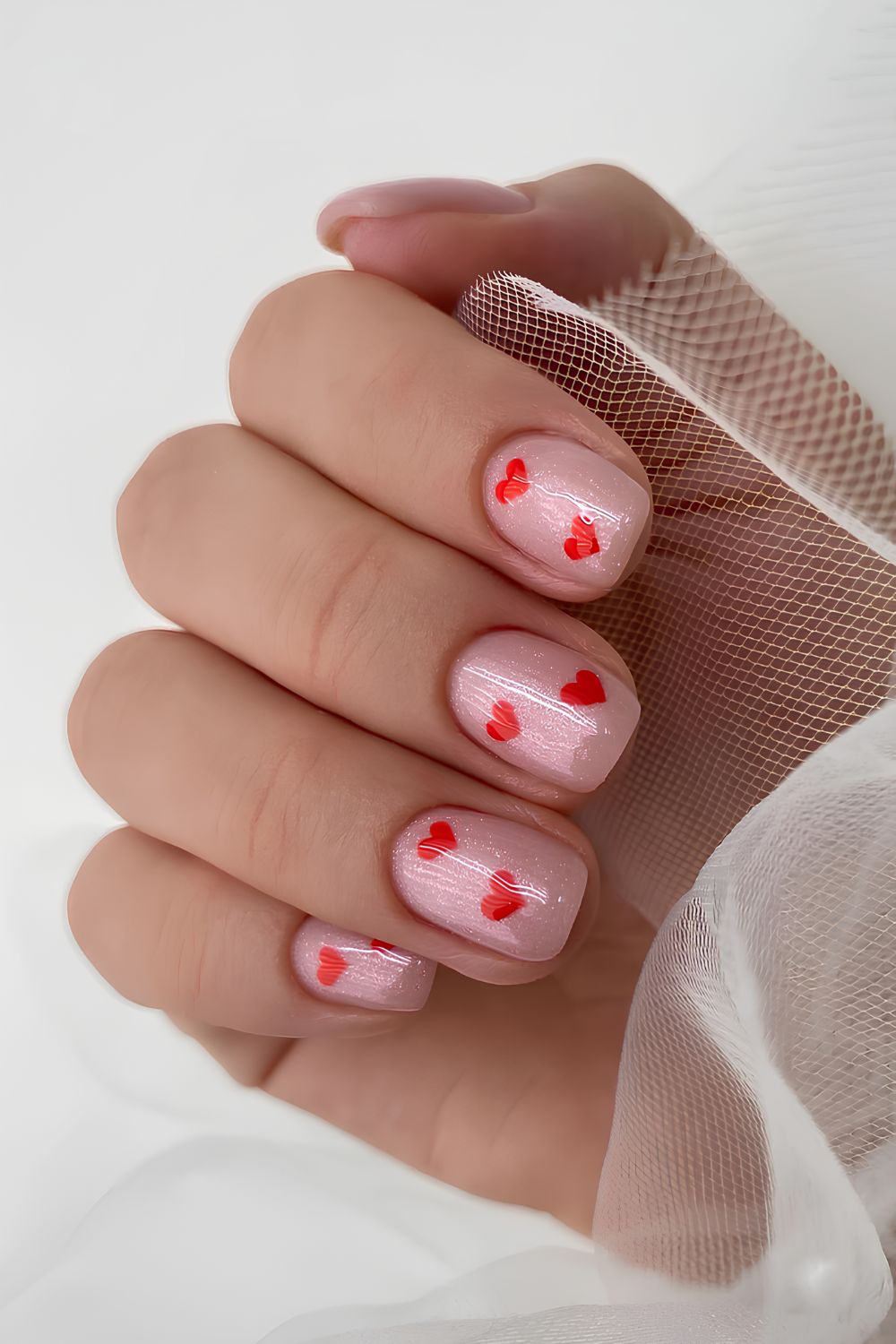 Shimmery pink mani with red hearts