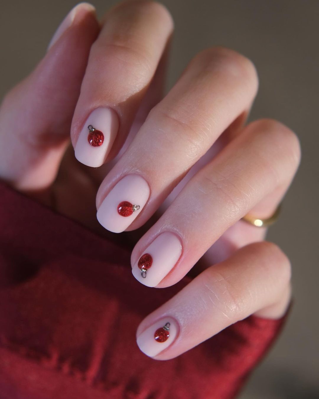 Short nude nails with red Christmas ornaments