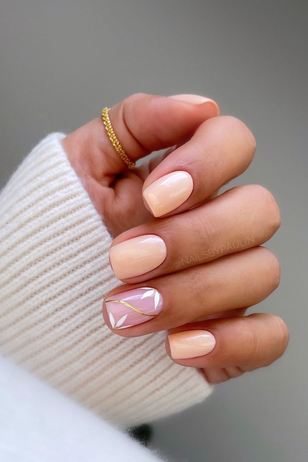 Soft peach nails with daisy accents