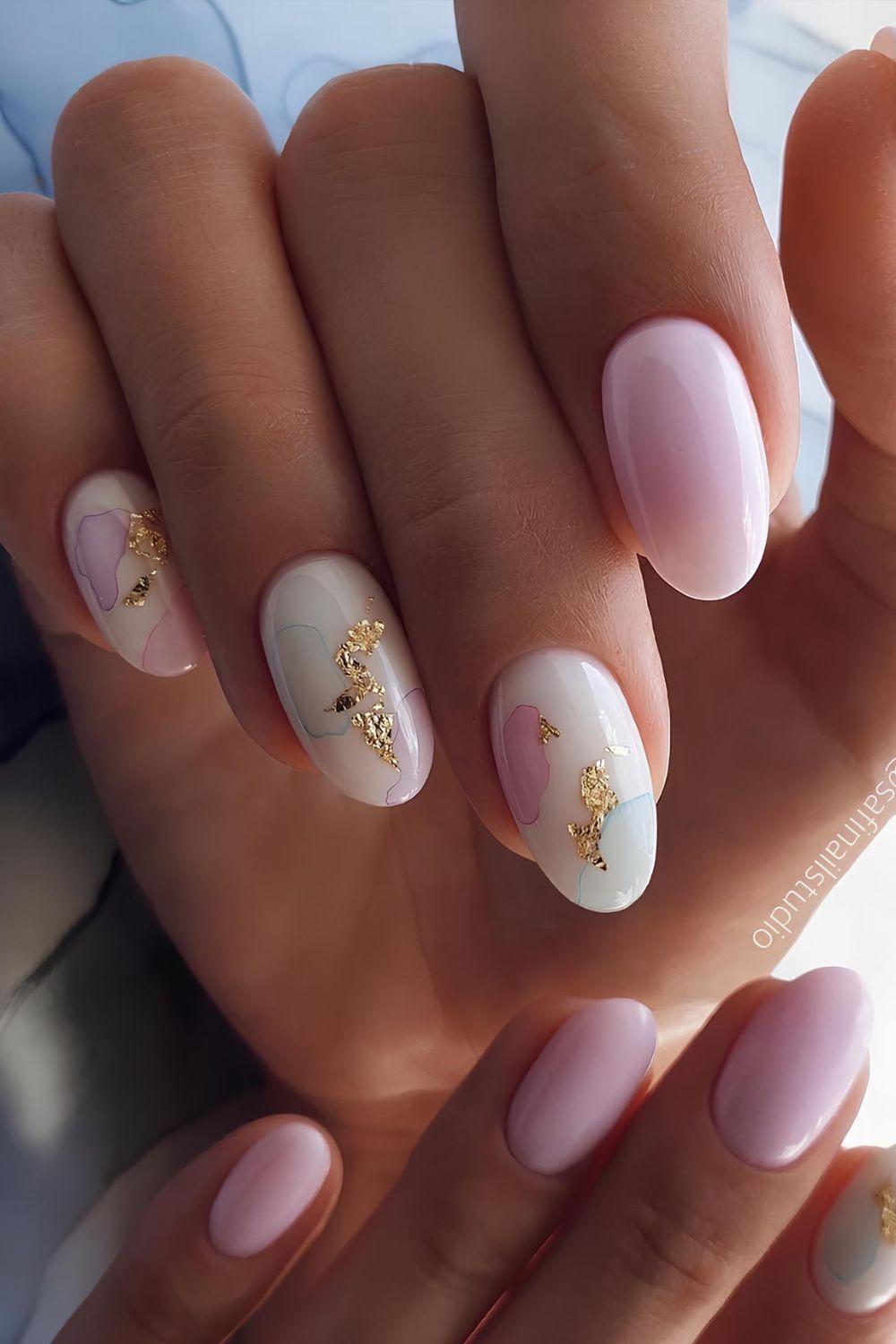 Soft pink and milky white nails with gold foil accents