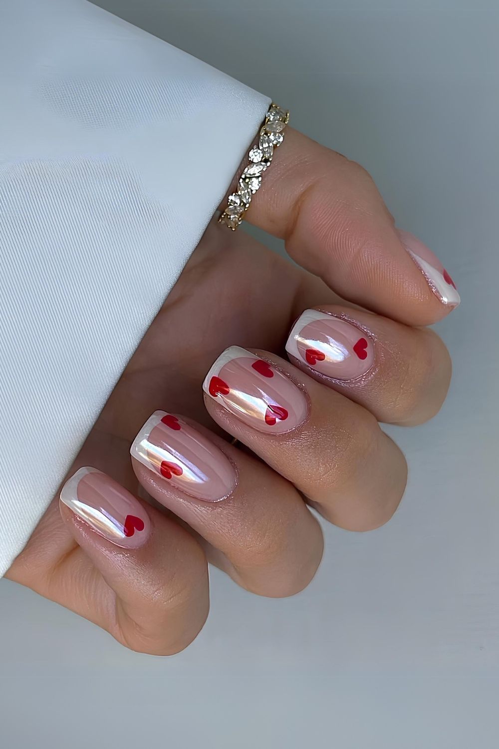 White chrome French mani with red hearts