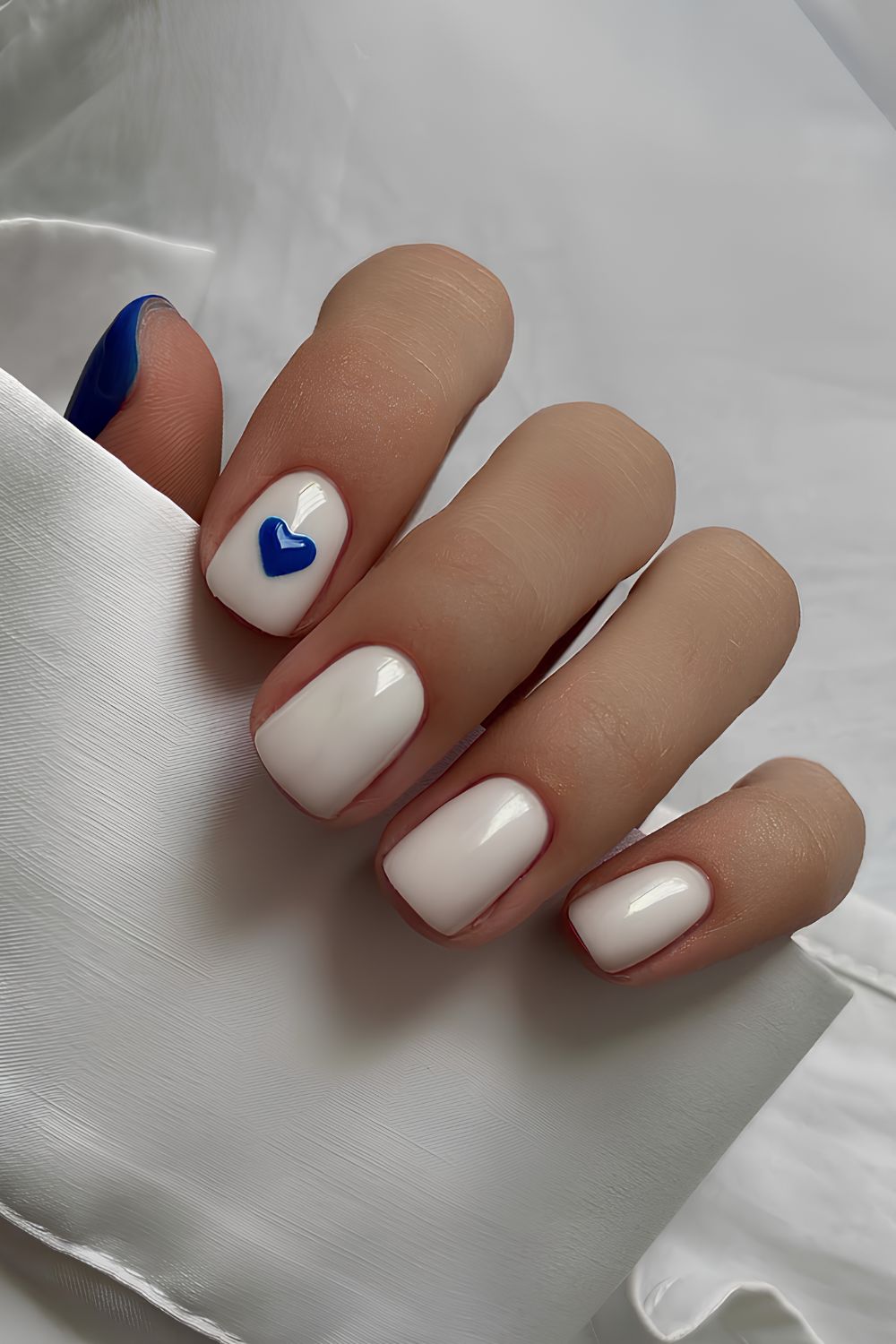 White nails with dark blue heart accent