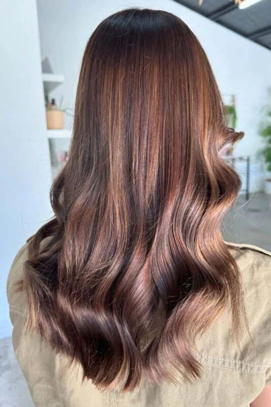 A woman with a warm bronze brown hair color.