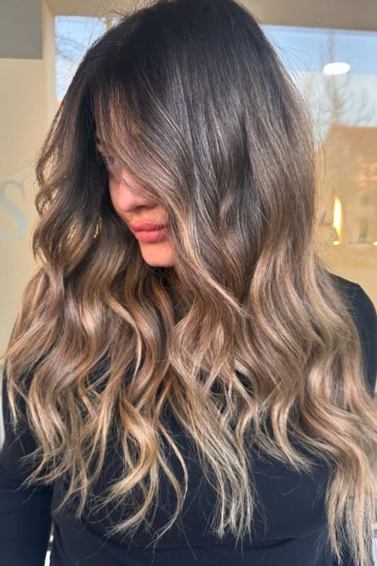 Woman with chocolate brown hair and bronde balayage.