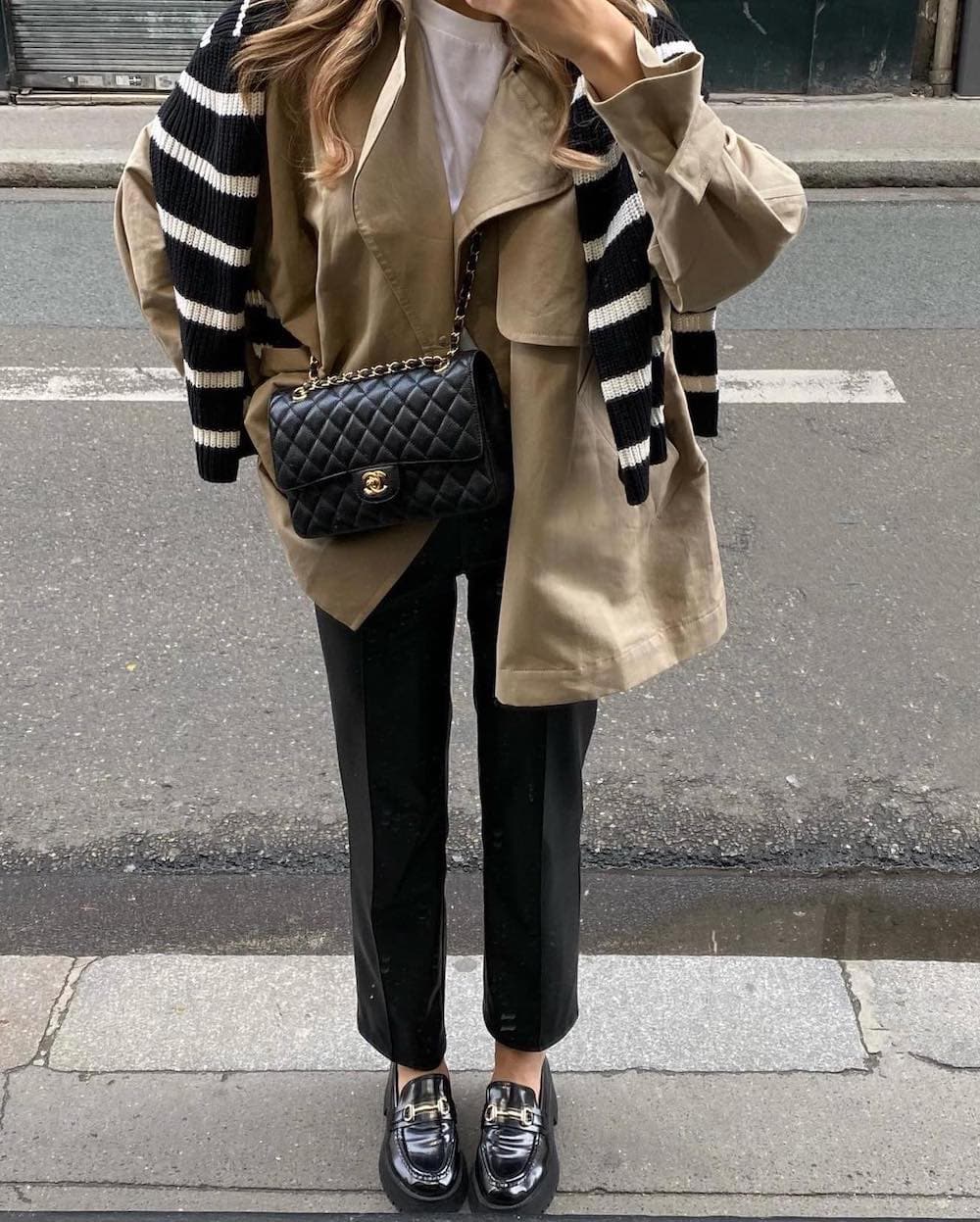 Woman wearing tailored trousers, loafers and a boxy coat over a t-shirt.