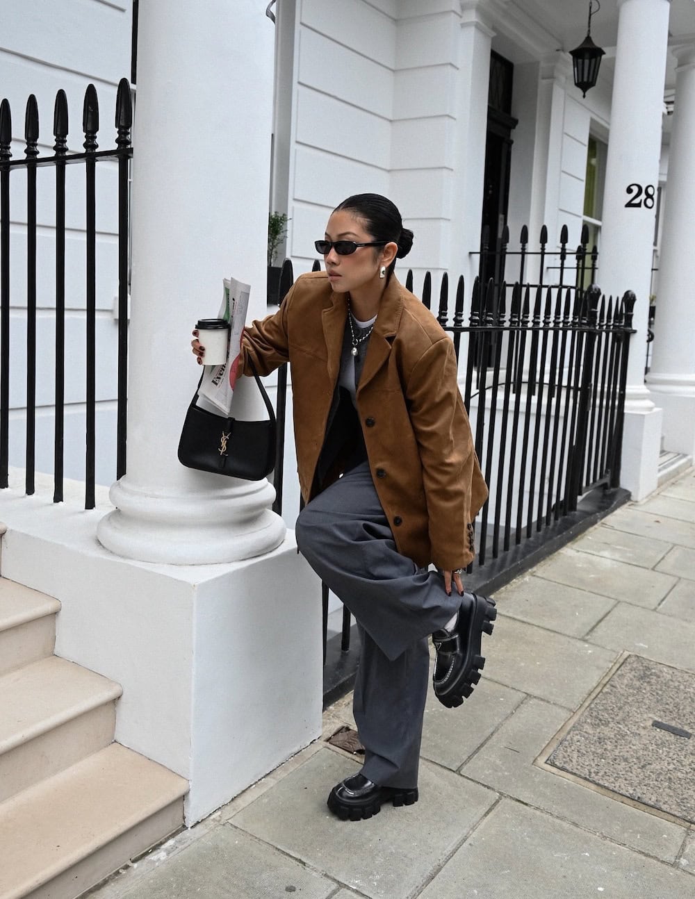 Woman wearing chunky loafers, trousers, and a blazer coat.