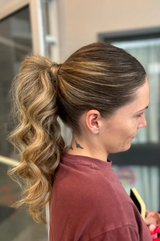 Woman with a high-glam ponytail with volume and waves.