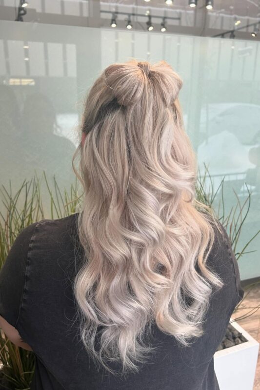 Woman with long waves styled into a bow updo.