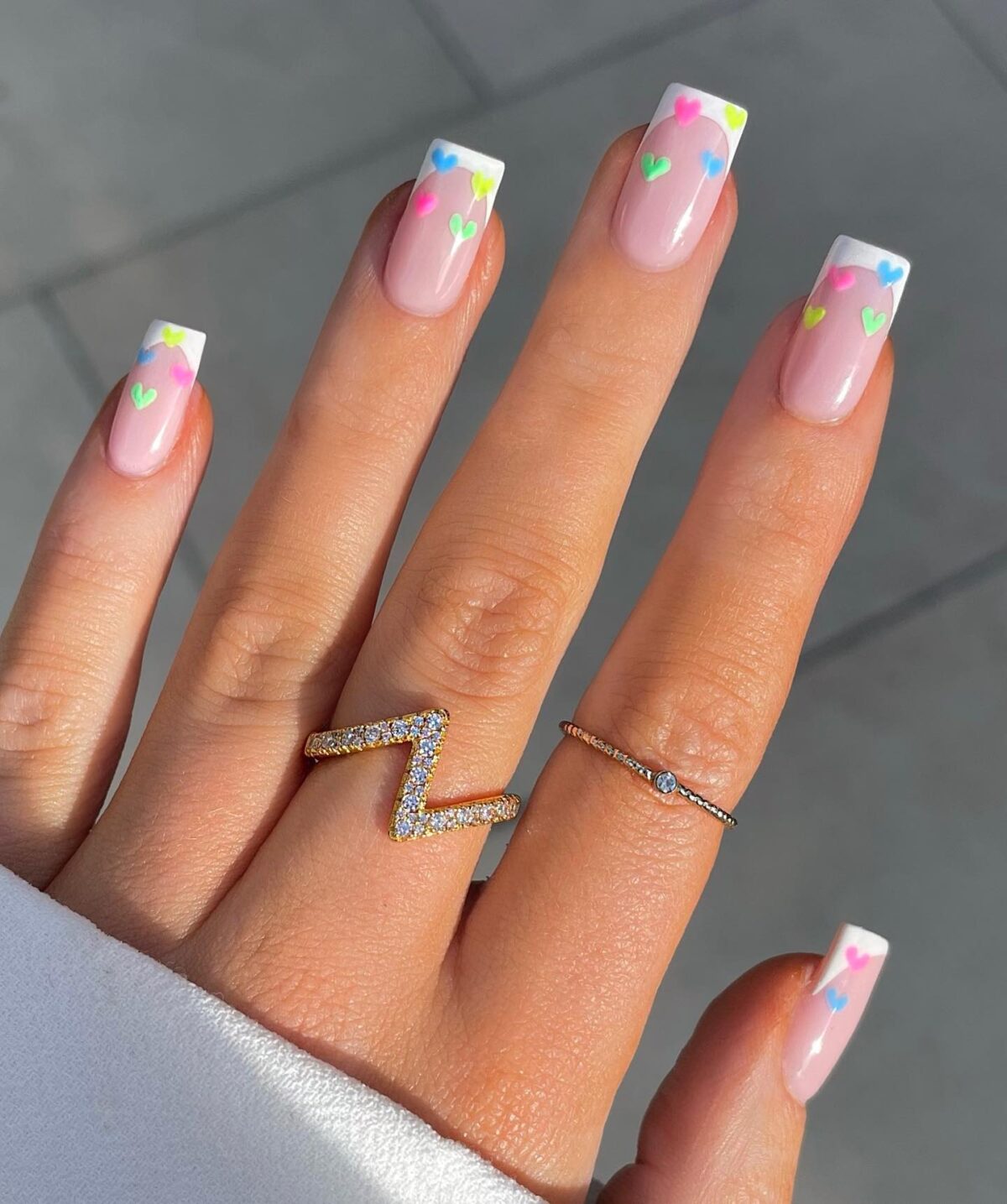 White French tip nails with pastel hearts