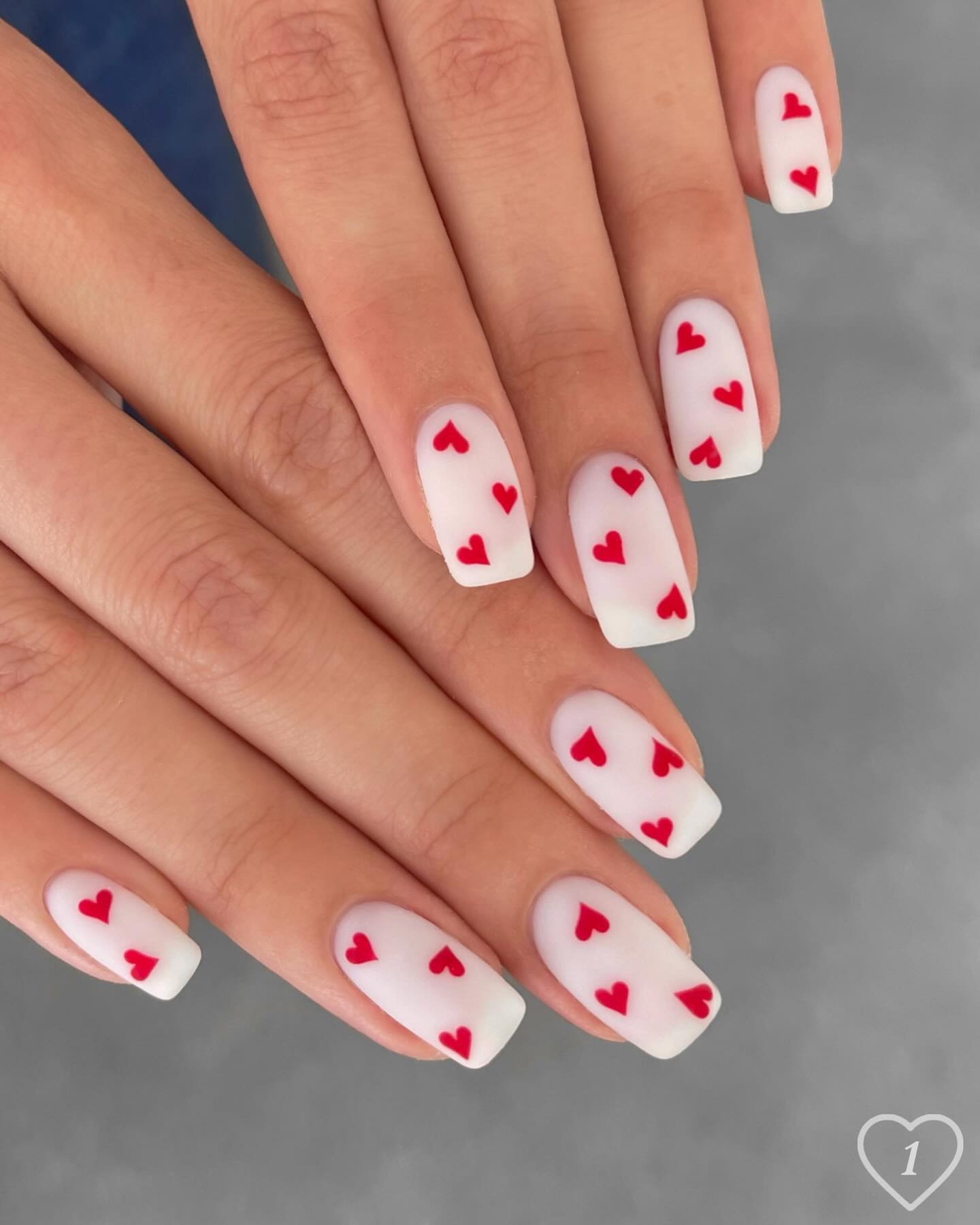 Milky white nails with red hearts