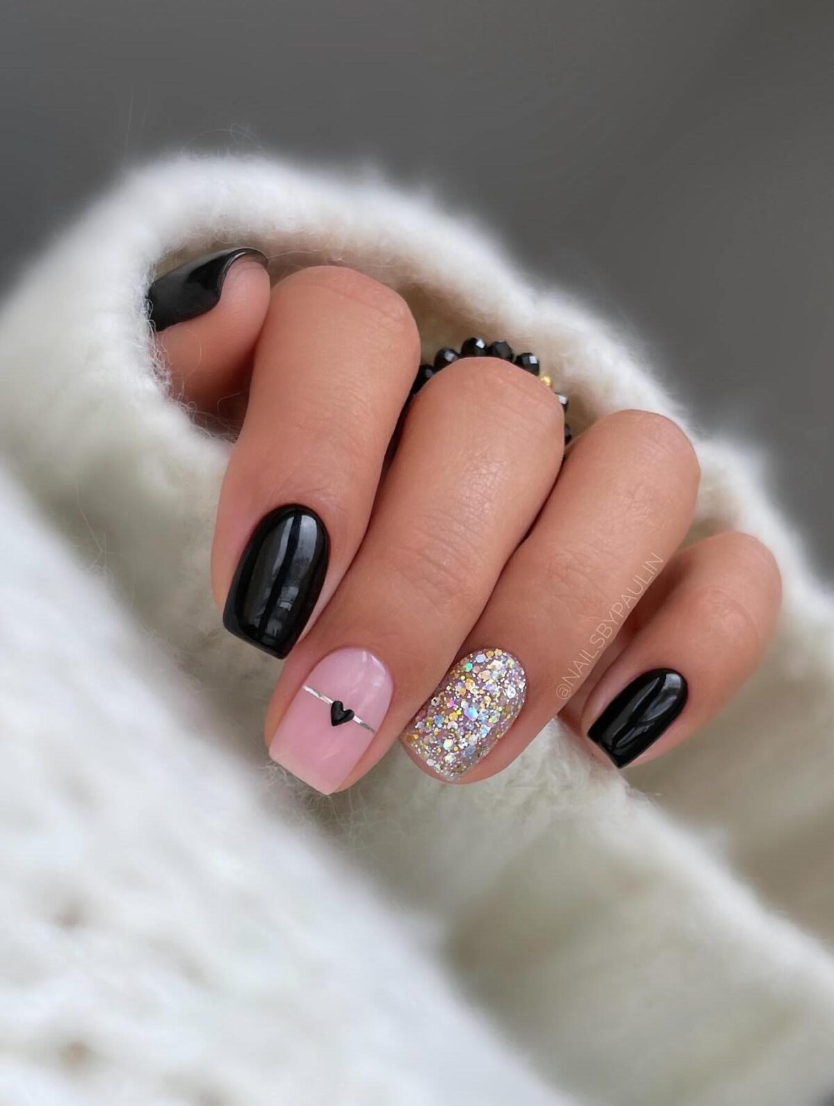 Short black nails with silver glitter and a heart