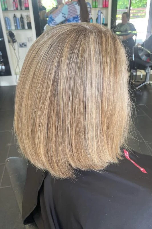 Honey blonde highlights blending gray in blonde hair softly.