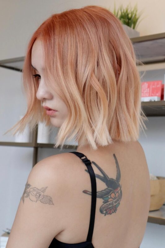 Woman with an ombre peach hair style.