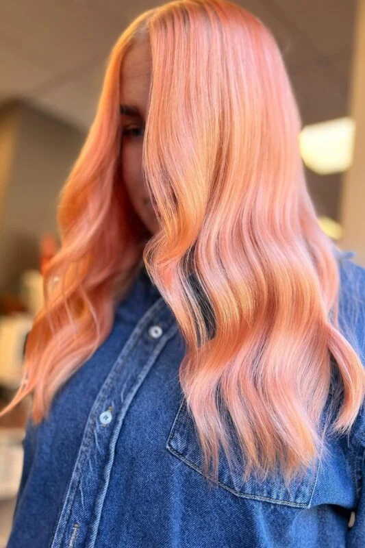 Woman with a peachy sunset hair color.