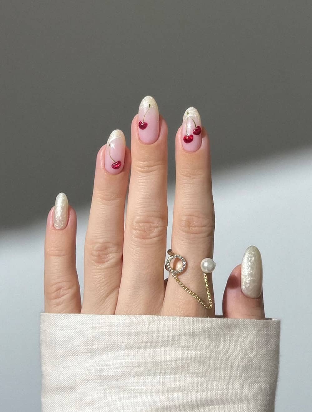 long nude nails with pearly white tips and cherry nail art