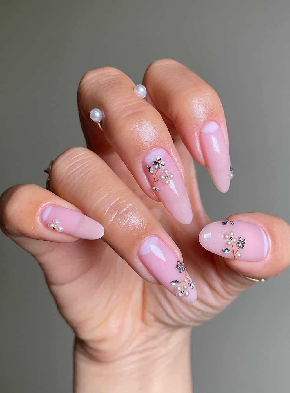 long pink almond nails with pearl and gem flowers