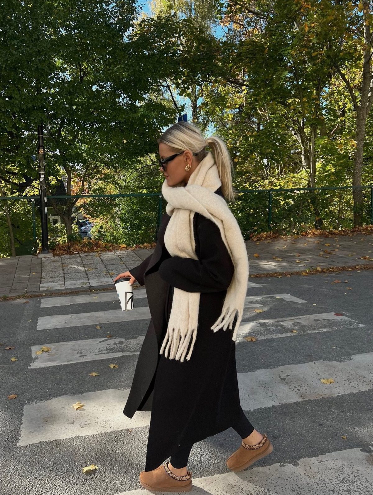 Warm winter outfit with a black coat white scarf and Ugg Tasman slippers