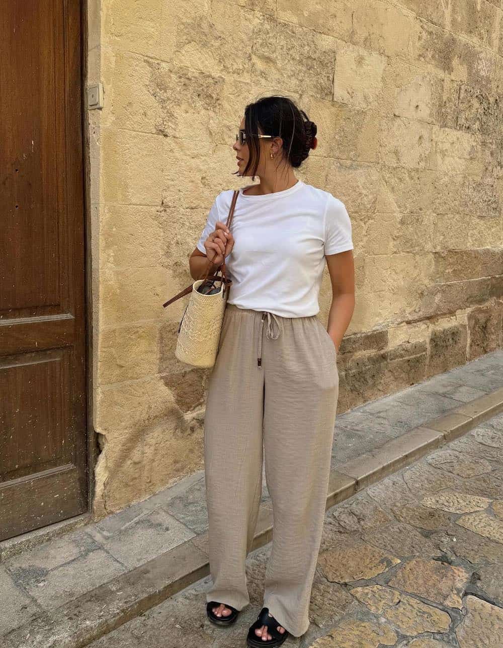 Woman wearing draw string linen pants with a white baby tee.