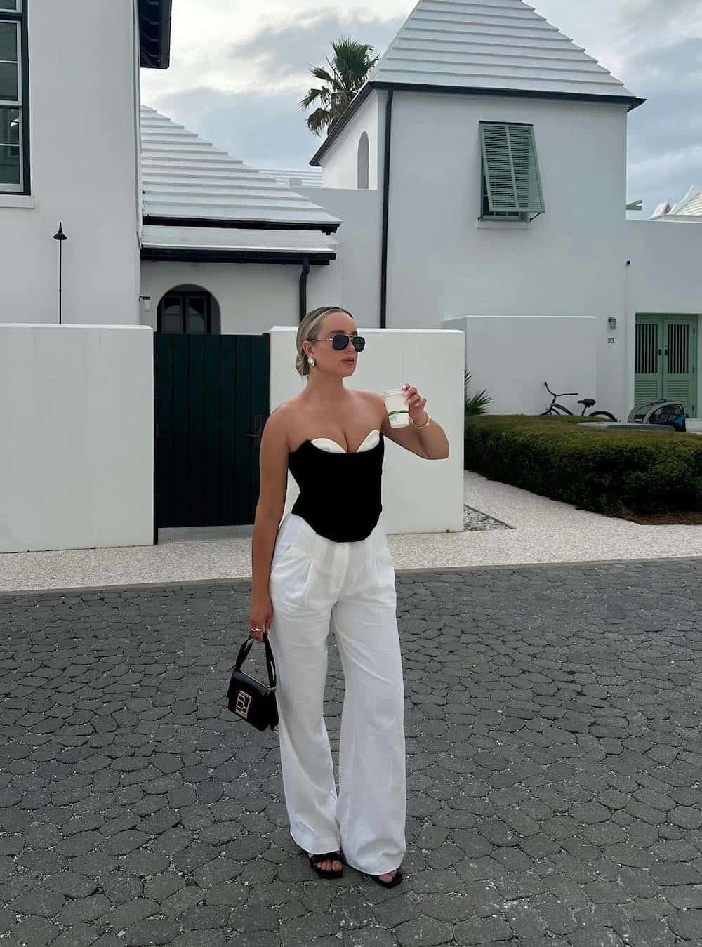 Woman wearing white linen pants with a black and white corset top.