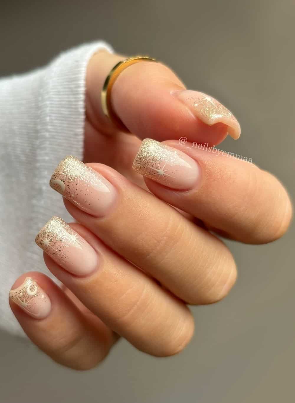 medium nude nails with gold glitter ombre and white star and moon art