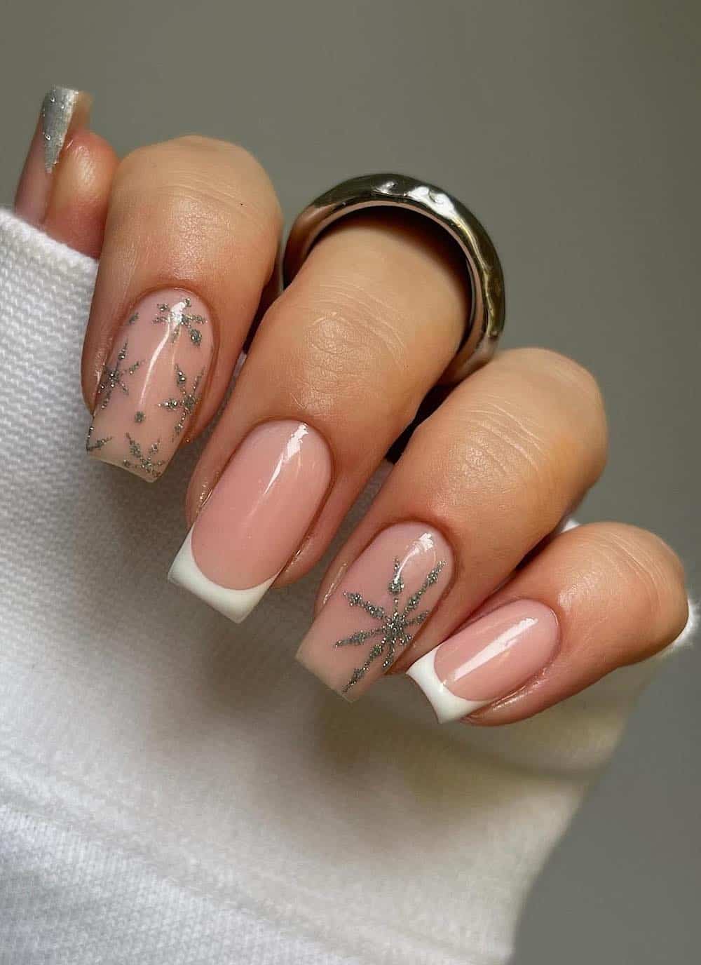 short nude nails with silver snowflake art and white tips