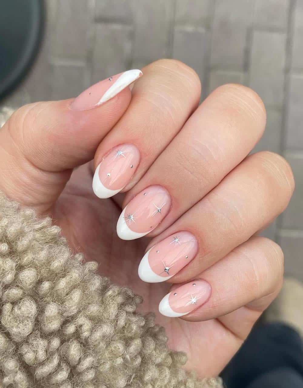 short nude nails with white tips and silver sparkles