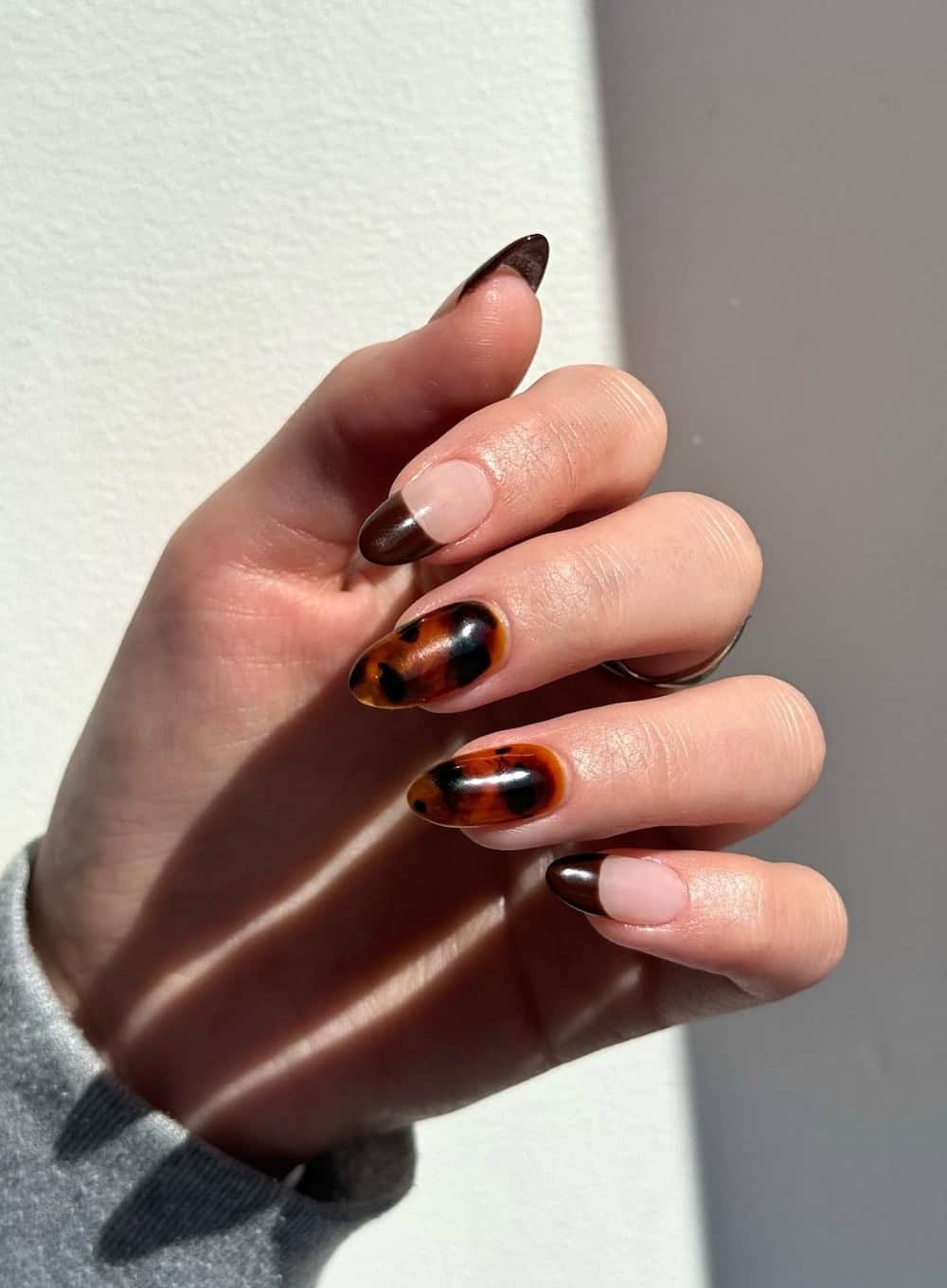 long nude nails with brown french tips and tortoise shell accent nails