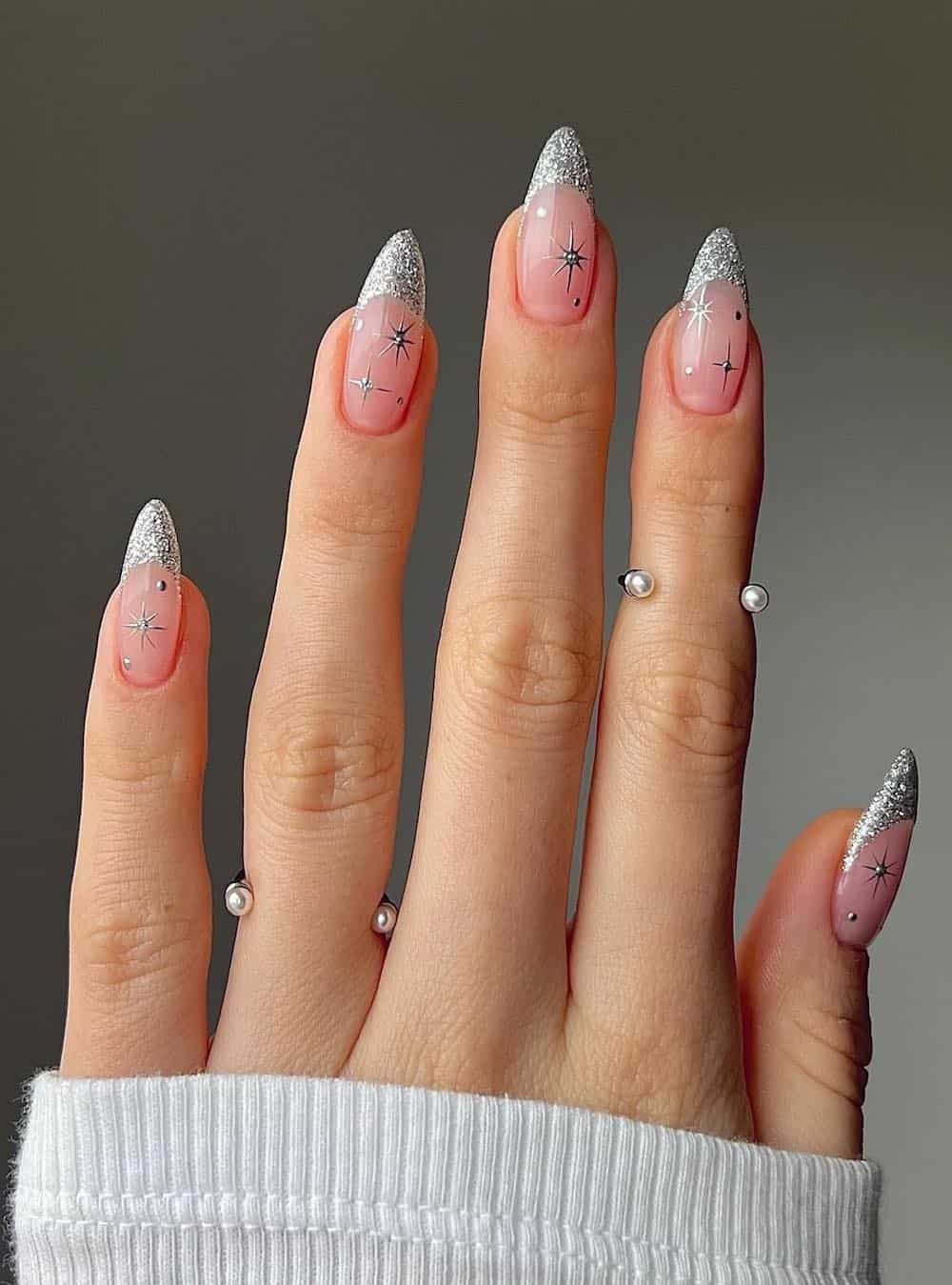 long nude pink almond nails with silver glitter tips and sparkles